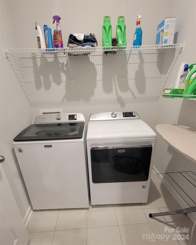 clothes washing area featuring separate washer and dryer and light tile patterned floors