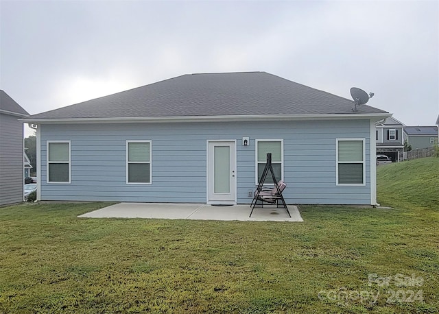 back of property with a lawn and a patio