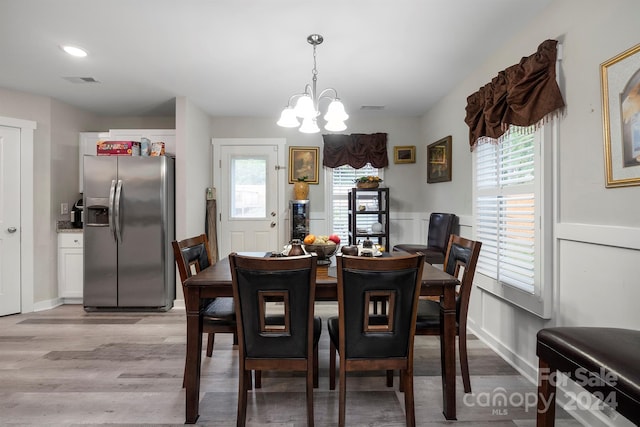 dining space featuring light hardwood / wood-style flooring and an inviting chandelier