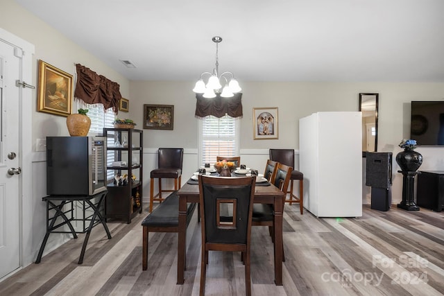 dining room featuring an inviting chandelier and light hardwood / wood-style floors