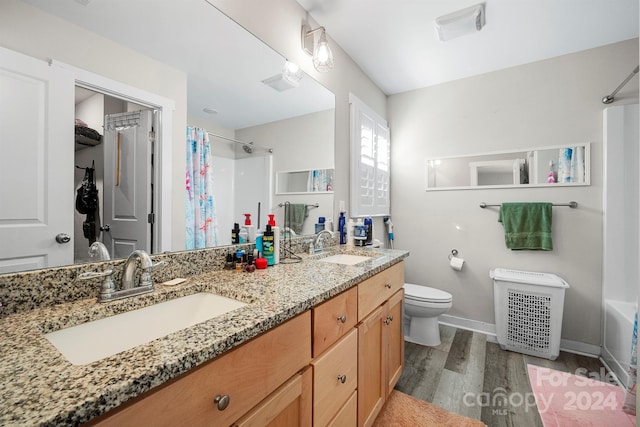 full bathroom with shower / bath combo, hardwood / wood-style floors, toilet, and vanity