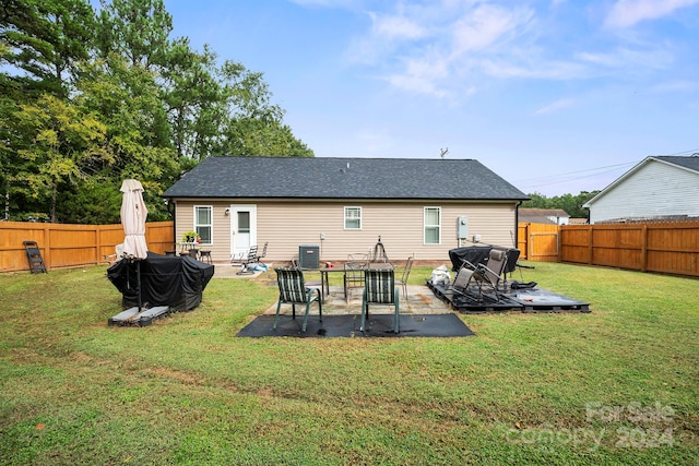 rear view of house with a yard, a patio, and central air condition unit