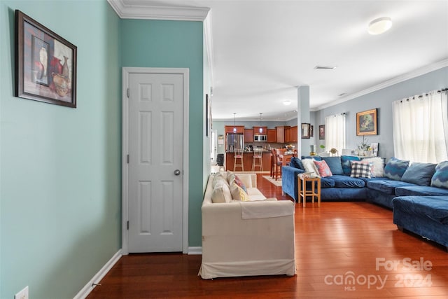 living room featuring dark wood-type flooring and crown molding