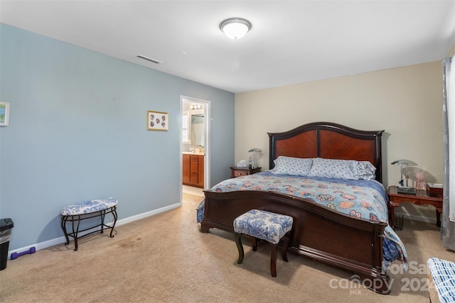 bedroom featuring light carpet and ensuite bathroom