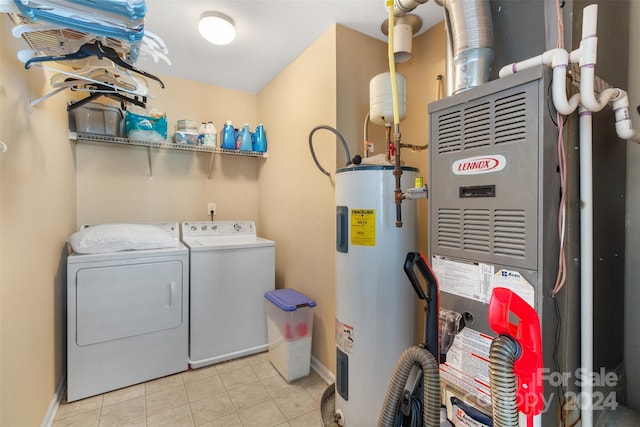 laundry room with heating unit, electric water heater, light tile patterned floors, and washing machine and dryer