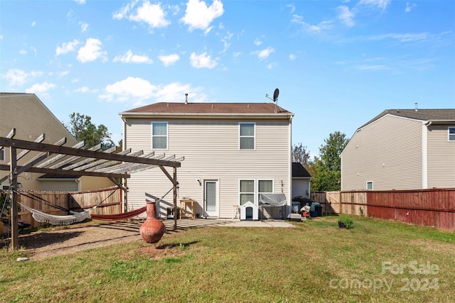 rear view of property featuring a lawn, a pergola, and a patio