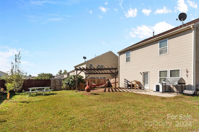 rear view of house with a pergola, a patio area, and a yard