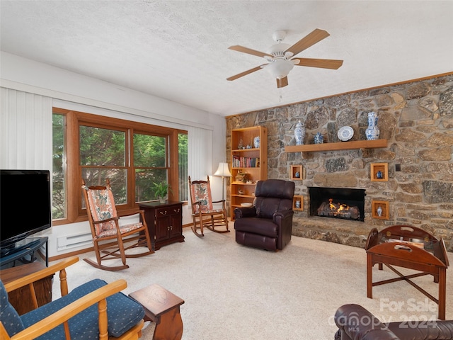 carpeted living room featuring a fireplace, a textured ceiling, and ceiling fan