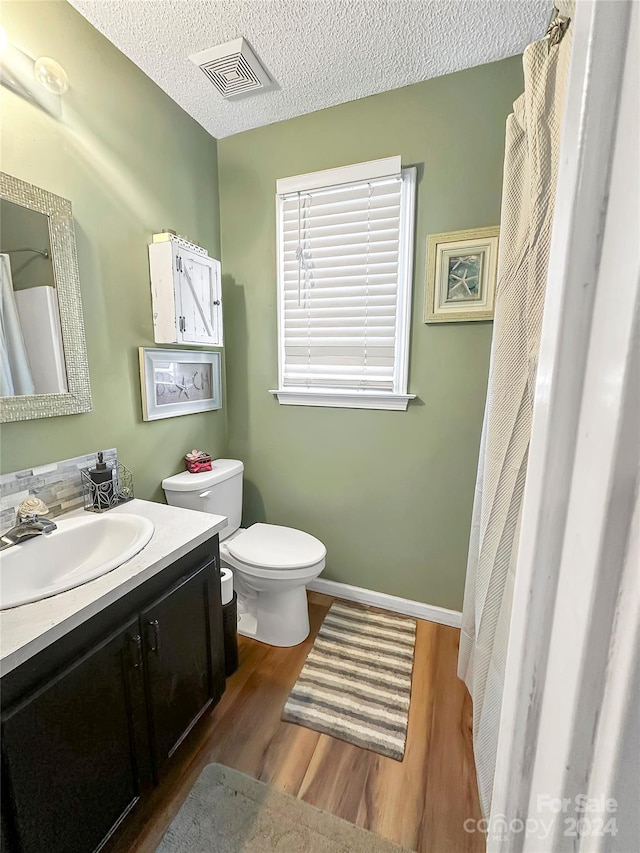 bathroom with vanity, hardwood / wood-style flooring, toilet, and a textured ceiling