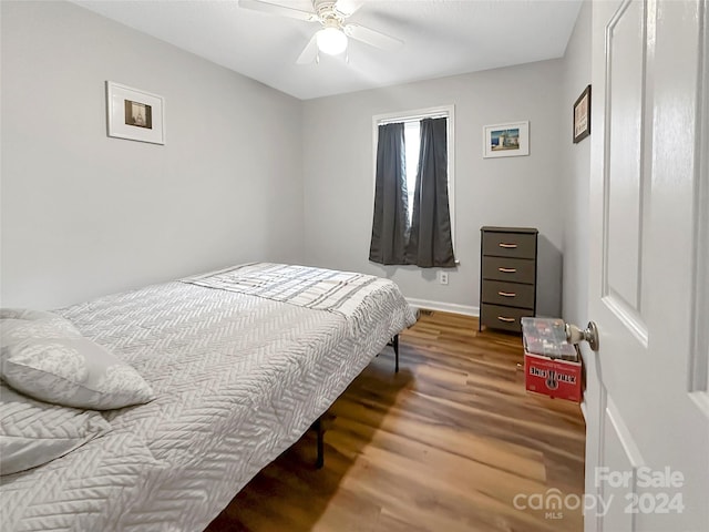 bedroom with baseboards, wood finished floors, and ceiling fan