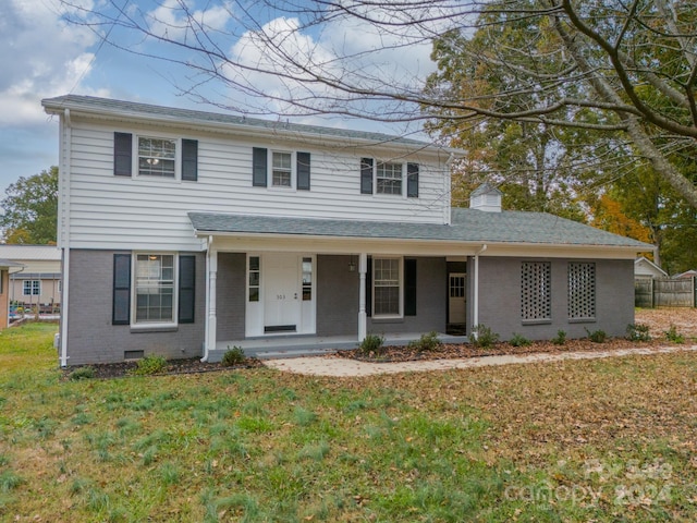 view of front of home with a front yard and covered porch