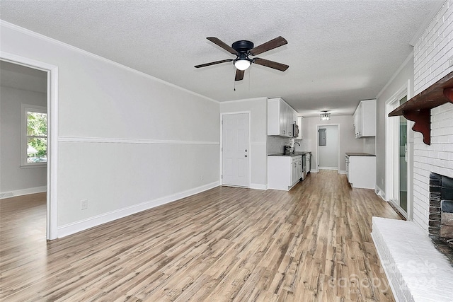 unfurnished living room with light wood-type flooring, a fireplace, and crown molding