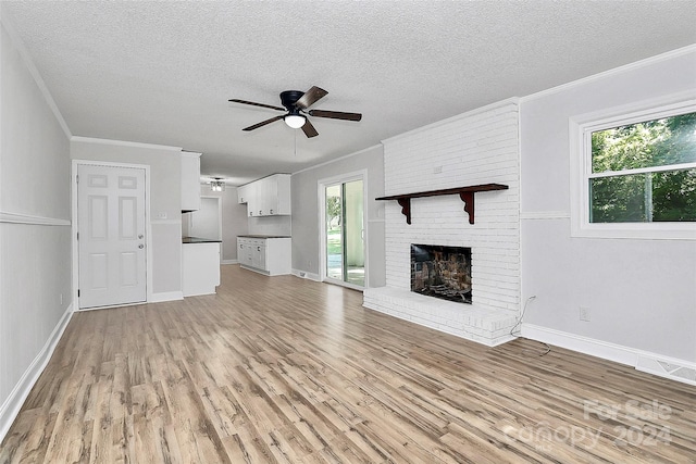 unfurnished living room with a textured ceiling, light hardwood / wood-style flooring, and a wealth of natural light