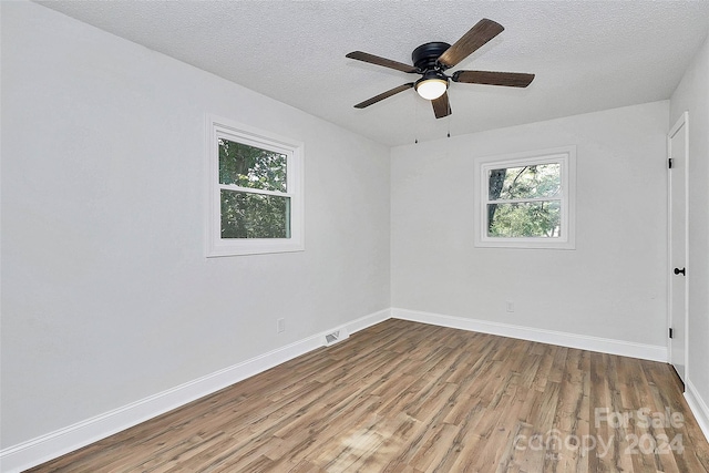 spare room featuring ceiling fan, hardwood / wood-style flooring, and a textured ceiling