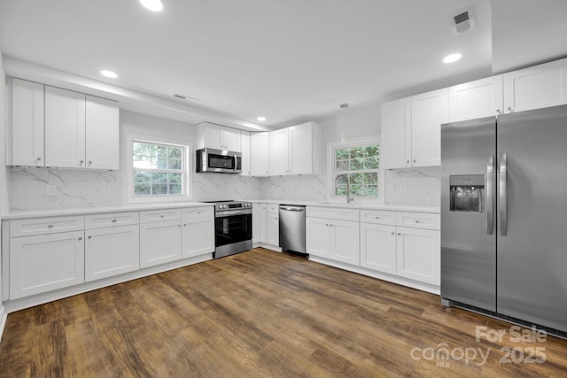 kitchen with white cabinets, stainless steel appliances, and dark wood-type flooring