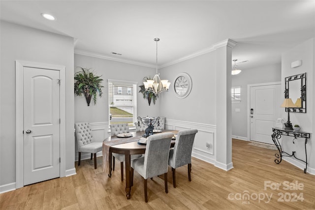 dining room featuring a notable chandelier, light wood-type flooring, and ornamental molding