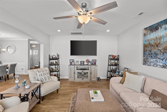 living room featuring ceiling fan with notable chandelier and light hardwood / wood-style floors