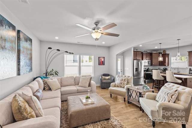 living room with ceiling fan and light hardwood / wood-style flooring