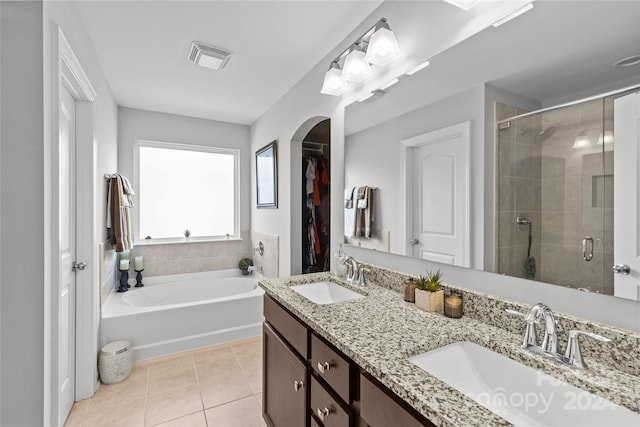 bathroom featuring tile patterned flooring, vanity, and plus walk in shower