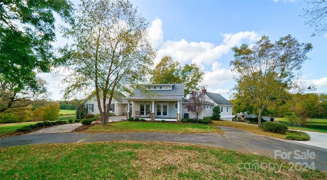 view of front of house featuring covered porch and a front yard