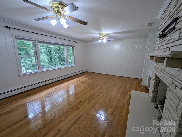 unfurnished living room featuring a baseboard radiator, hardwood / wood-style flooring, a fireplace, and ceiling fan