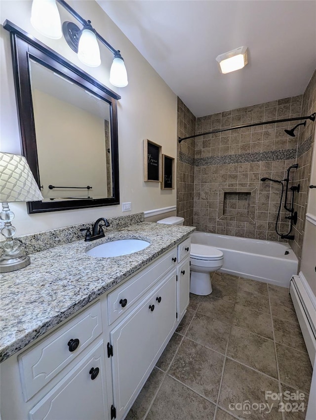 full bathroom featuring vanity, toilet, a baseboard radiator, and tiled shower / bath