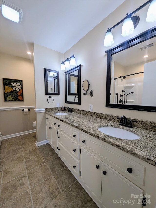 bathroom with vanity, a shower, and toilet