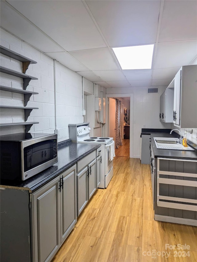 kitchen featuring light hardwood / wood-style flooring, sink, gray cabinetry, a drop ceiling, and stainless steel appliances