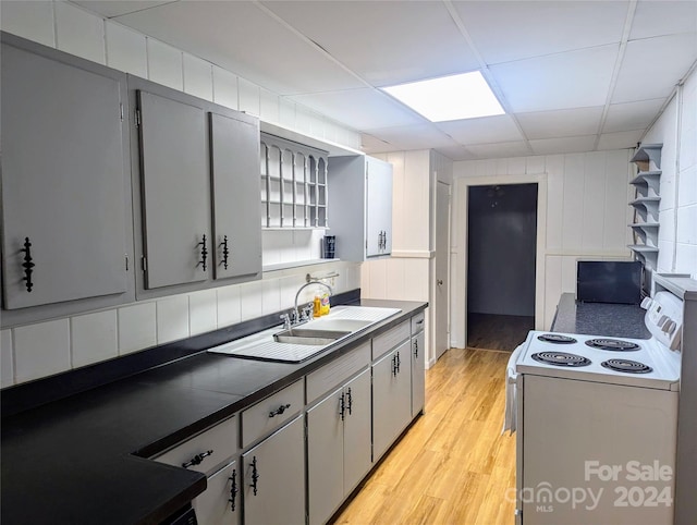 kitchen featuring a paneled ceiling, gray cabinetry, light hardwood / wood-style floors, white range with electric stovetop, and sink