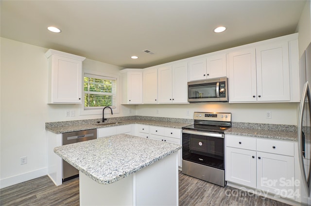 kitchen featuring dark hardwood / wood-style flooring, white cabinetry, stainless steel appliances, sink, and a center island