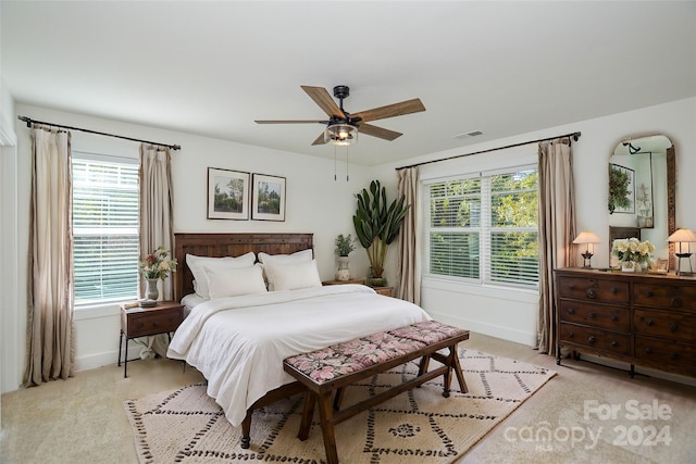 carpeted bedroom with multiple windows and ceiling fan