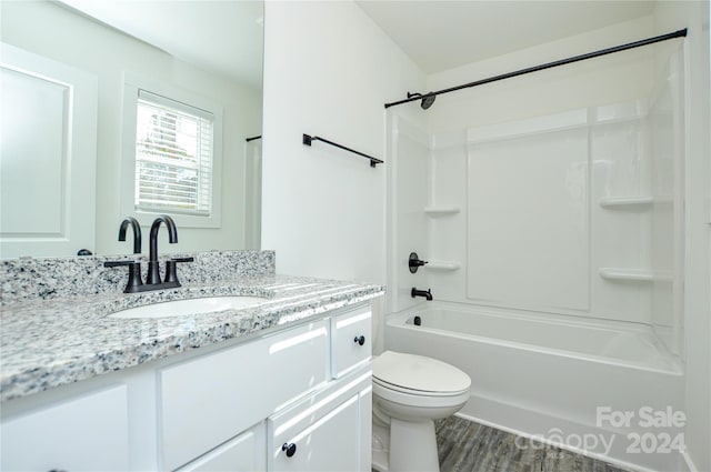 full bathroom featuring vanity, hardwood / wood-style floors, bathing tub / shower combination, and toilet