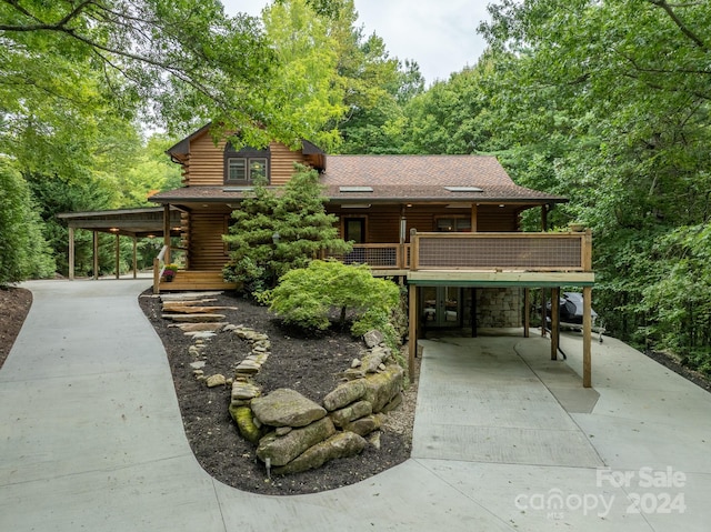 log-style house featuring a carport