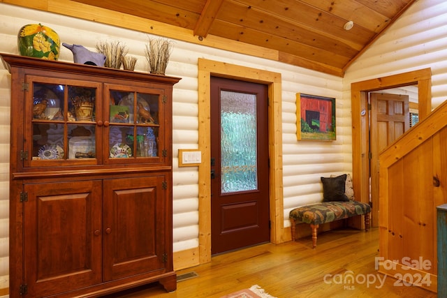 entrance foyer with light wood-type flooring, log walls, vaulted ceiling, and wooden ceiling