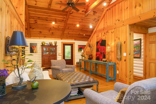 living room featuring vaulted ceiling with beams, light hardwood / wood-style floors, and wooden ceiling