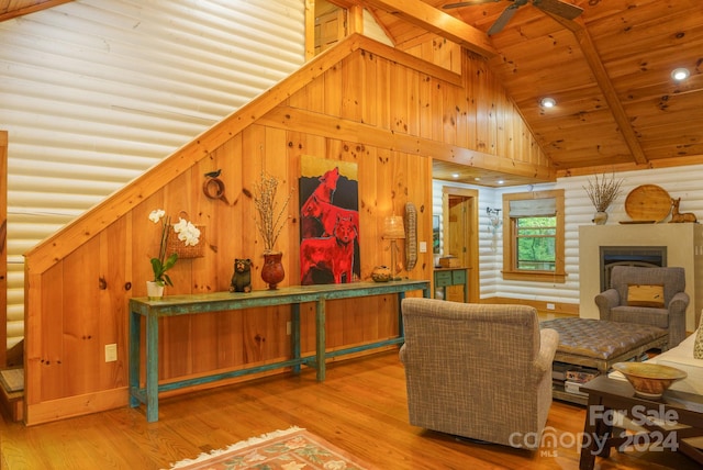 living room with beamed ceiling, ceiling fan, light hardwood / wood-style flooring, and high vaulted ceiling