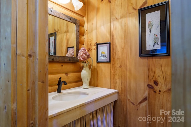 bathroom with wood walls and sink