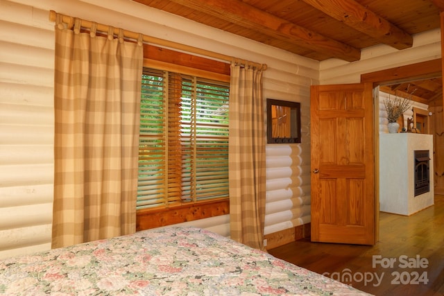 unfurnished bedroom featuring wooden ceiling, log walls, hardwood / wood-style floors, and beamed ceiling