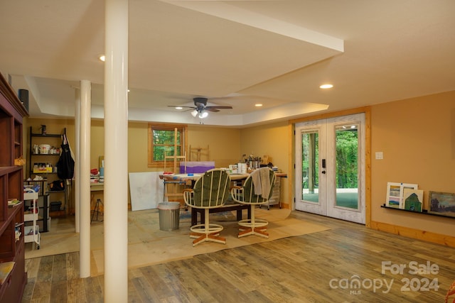 dining room with a tray ceiling, ceiling fan, hardwood / wood-style flooring, and french doors