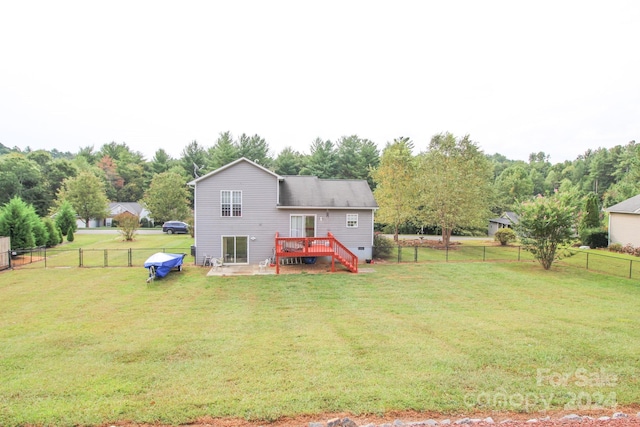 rear view of property featuring a deck and a lawn