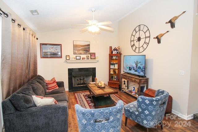 living room featuring vaulted ceiling, ceiling fan, hardwood / wood-style flooring, and a fireplace