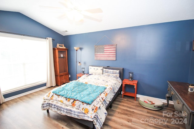 bedroom with ceiling fan, lofted ceiling, and dark hardwood / wood-style floors