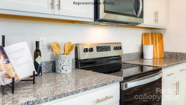 kitchen with stone counters, white cabinets, and appliances with stainless steel finishes