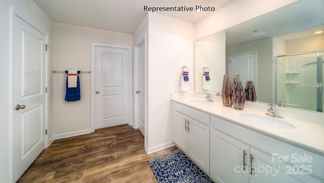 bathroom with a shower with door, vanity, and wood-type flooring