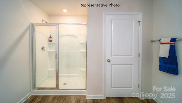 bathroom with hardwood / wood-style flooring and walk in shower