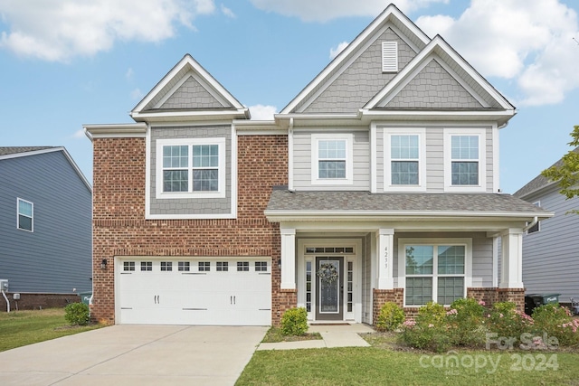 craftsman-style home featuring a front yard, a porch, and a garage