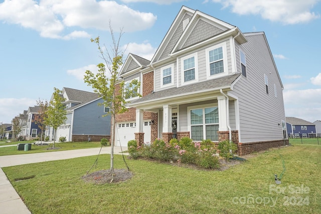 craftsman house featuring a garage and a front lawn