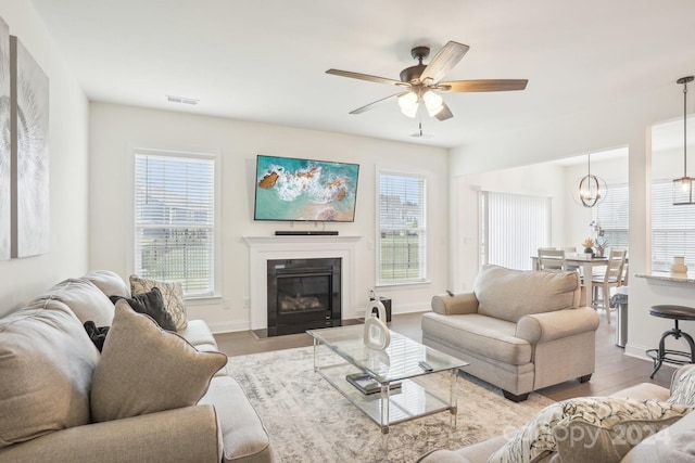 living room featuring light hardwood / wood-style floors, ceiling fan, and plenty of natural light