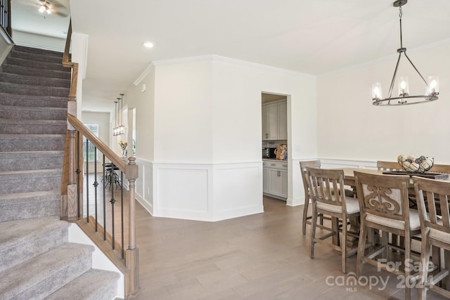 dining area with a notable chandelier, hardwood / wood-style flooring, and ornamental molding