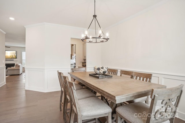 dining room with ornamental molding, dark wood-type flooring, and a notable chandelier